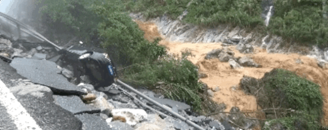 图为事发地点,山洪把路面的柏油层冲得支离破碎